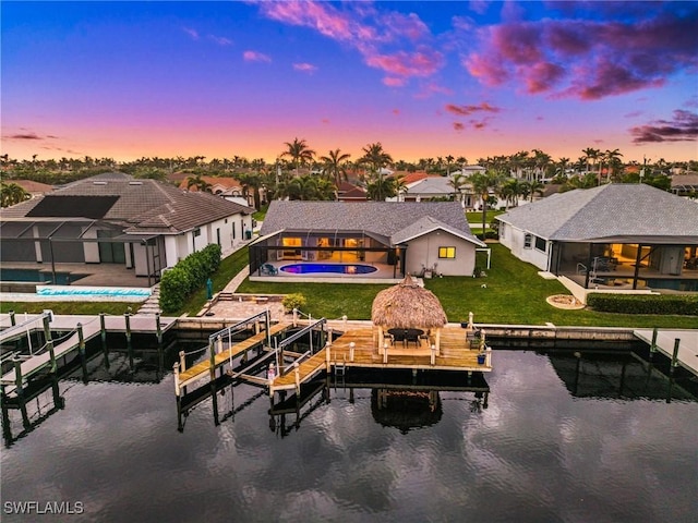 exterior space with a water view, a gazebo, glass enclosure, a lawn, and a patio