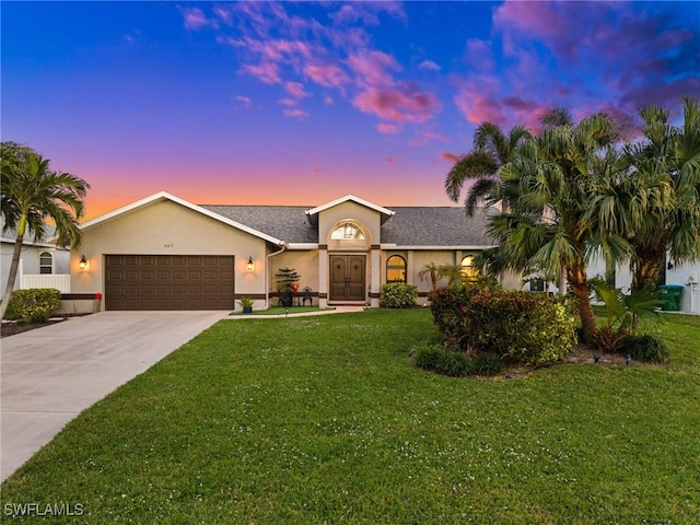 ranch-style home featuring an attached garage, driveway, roof with shingles, stucco siding, and a front lawn