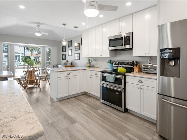 kitchen featuring white cabinets, kitchen peninsula, and stainless steel appliances