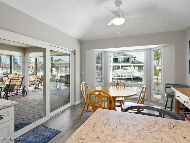 dining room with plenty of natural light, dark wood-type flooring, and lofted ceiling