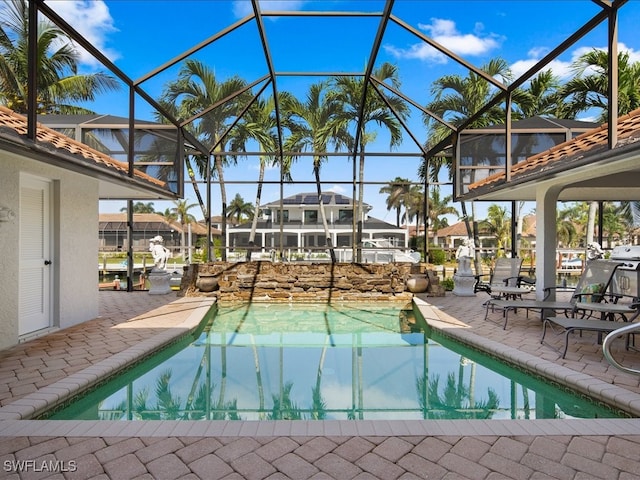 view of swimming pool featuring glass enclosure and a patio