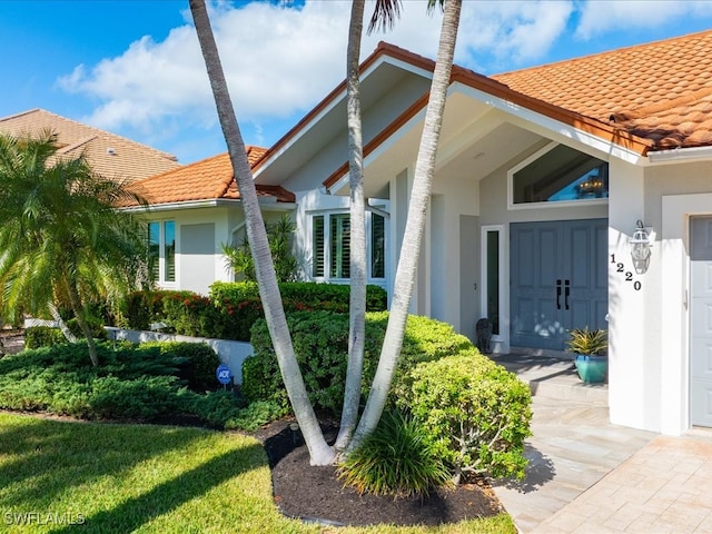 doorway to property with a lawn