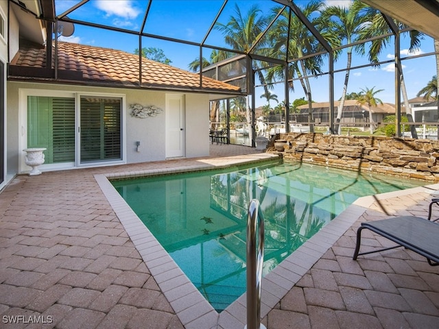 view of swimming pool with glass enclosure and a patio area