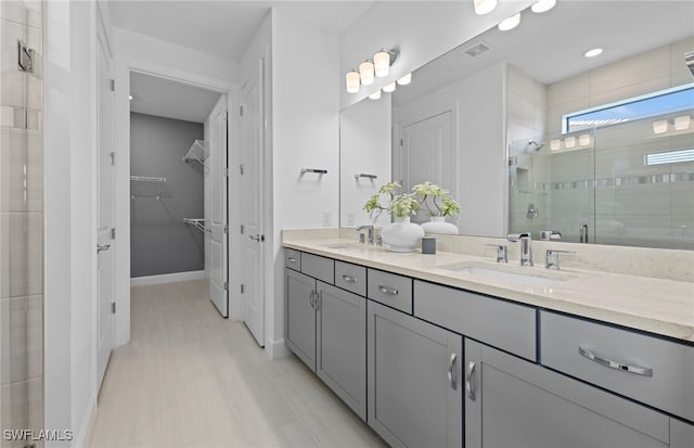 bathroom with vanity and a shower with door