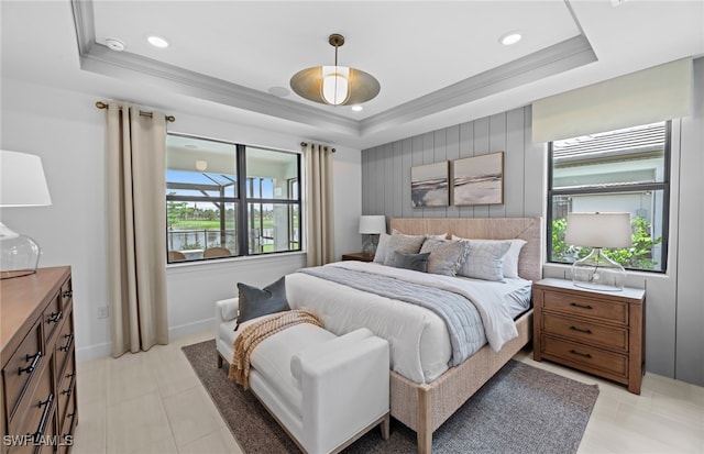 tiled bedroom featuring a tray ceiling and crown molding