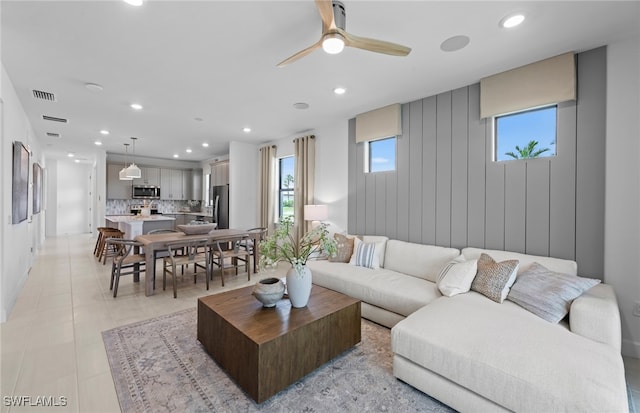 living room featuring a healthy amount of sunlight, ceiling fan, and light tile patterned flooring