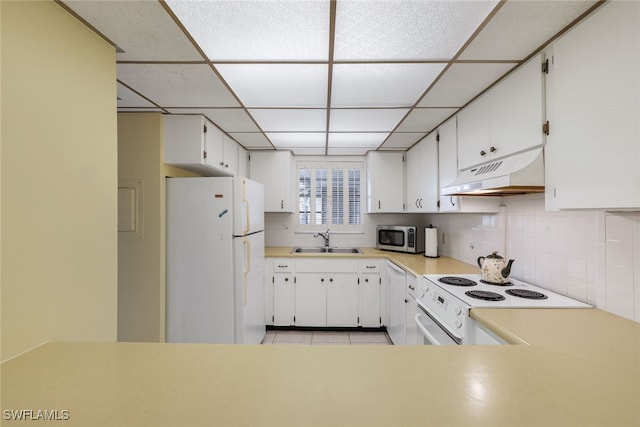 kitchen with white cabinetry, sink, a drop ceiling, white appliances, and light tile patterned floors