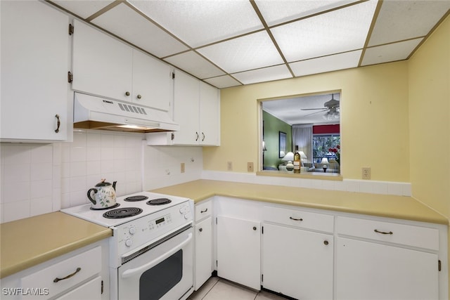 kitchen featuring electric range, ceiling fan, backsplash, a paneled ceiling, and white cabinets