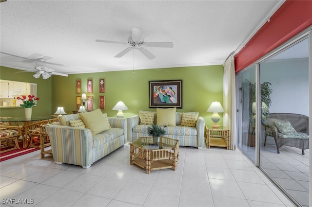 living room featuring ceiling fan, light tile patterned flooring, a textured ceiling, and ornamental molding