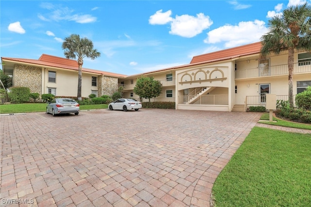 1200 Cherrystone Ct Unit B209, Naples, FL 34102 - view of front of house with uncovered parking, stucco siding, and a tile roof