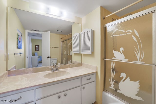 full bathroom featuring shower / bath combination with glass door, vanity, and toilet