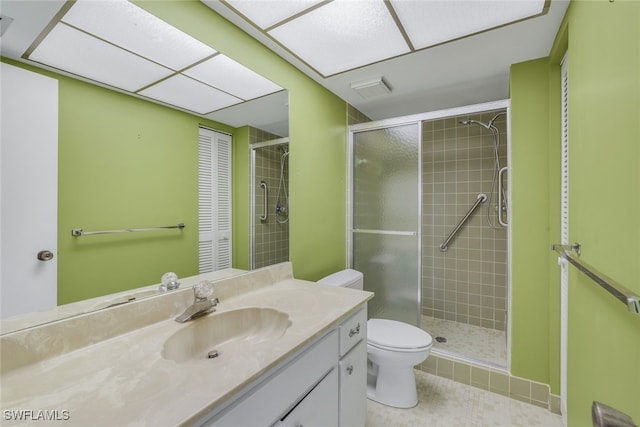 bathroom featuring tile patterned floors, vanity, toilet, and an enclosed shower