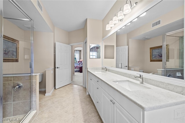 bathroom featuring tile patterned flooring, an enclosed shower, vanity, and toilet