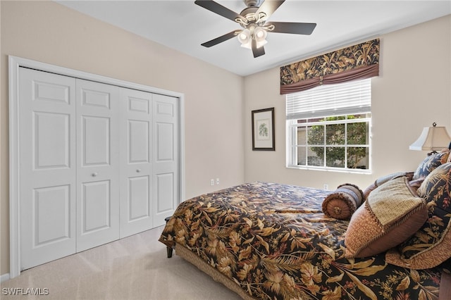 bedroom featuring ceiling fan, a closet, and light colored carpet