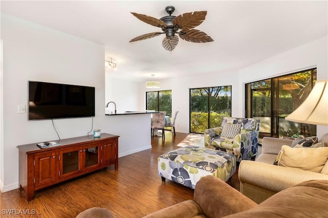 living room with dark hardwood / wood-style flooring and ceiling fan