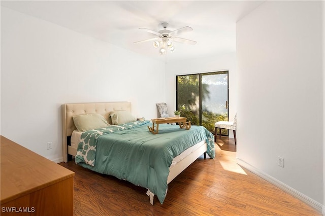 bedroom featuring access to outside, ceiling fan, and dark hardwood / wood-style flooring