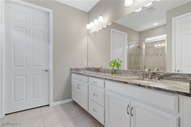 bathroom featuring tile patterned flooring, vanity, and walk in shower