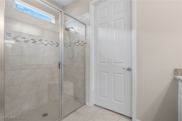 bathroom featuring tile patterned floors, vanity, and a shower with shower door