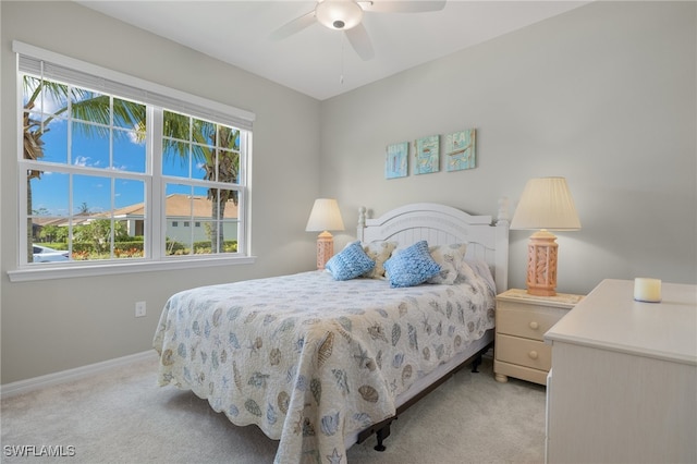 carpeted bedroom featuring multiple windows and ceiling fan