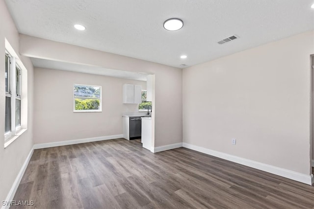 unfurnished living room with light hardwood / wood-style floors and a textured ceiling