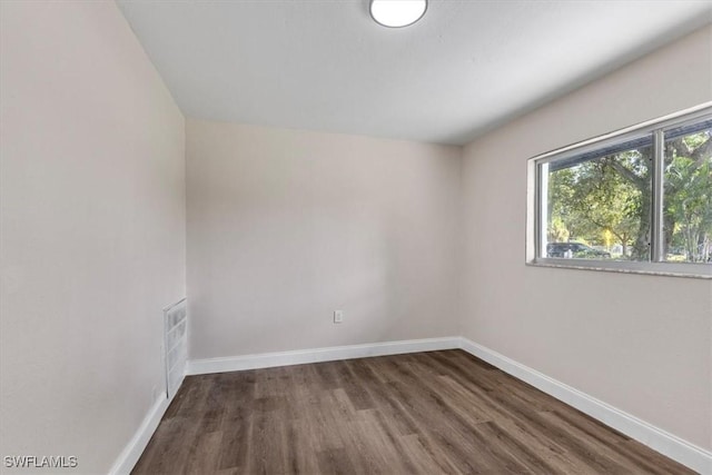 unfurnished room with dark wood-type flooring