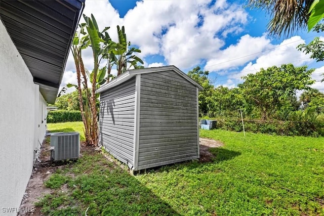 view of outbuilding with central AC and a lawn