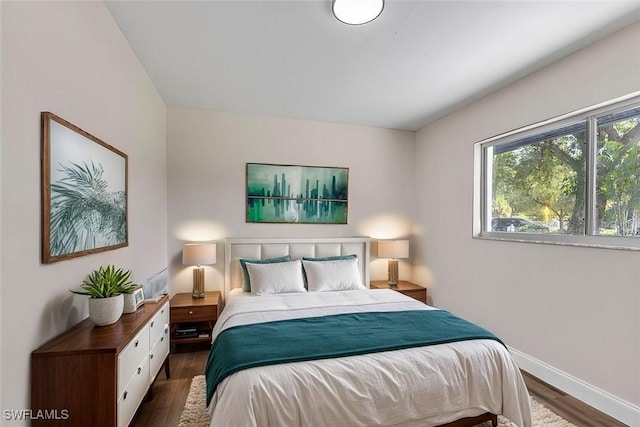 bedroom with dark hardwood / wood-style floors