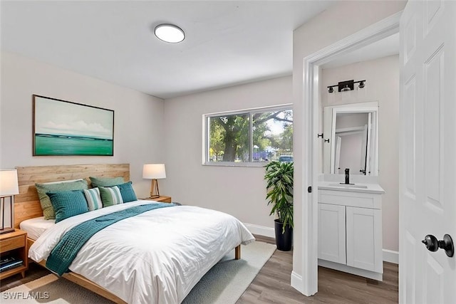 bedroom with light hardwood / wood-style floors and connected bathroom