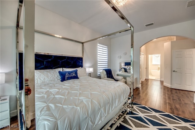 bedroom with hardwood / wood-style floors and ensuite bath