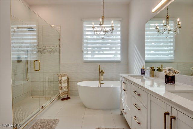 bathroom featuring vanity, an inviting chandelier, tile walls, independent shower and bath, and tile patterned flooring