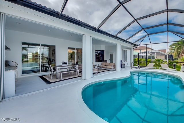 view of swimming pool with glass enclosure, a patio, and an outdoor hangout area