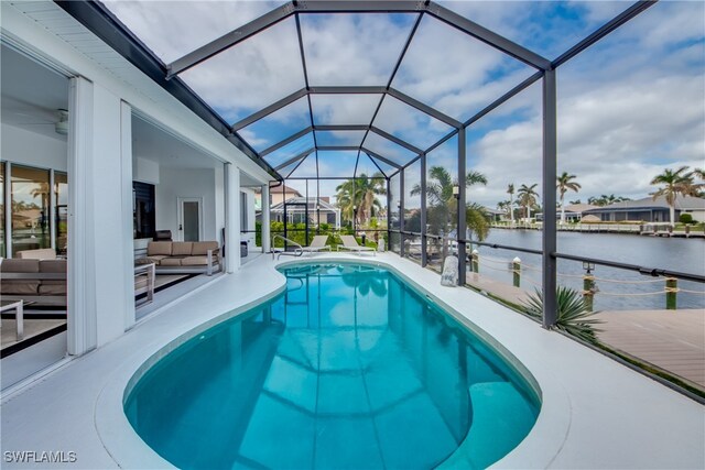 view of swimming pool featuring glass enclosure, a patio area, a water view, and an outdoor hangout area