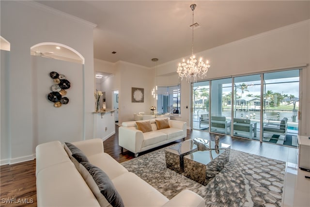 living room featuring a chandelier, dark hardwood / wood-style floors, ornamental molding, and a water view