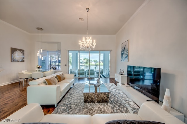 living room featuring dark wood-type flooring, a notable chandelier, and ornamental molding