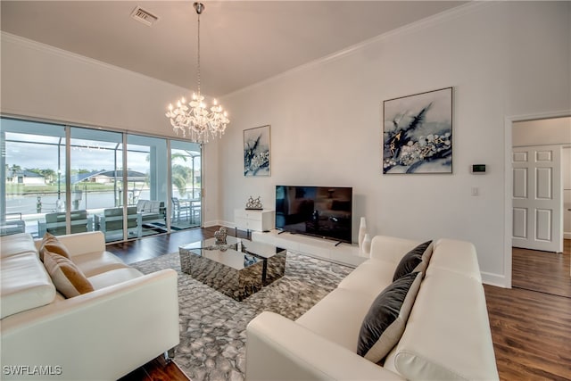 living room with dark hardwood / wood-style floors, crown molding, and a chandelier