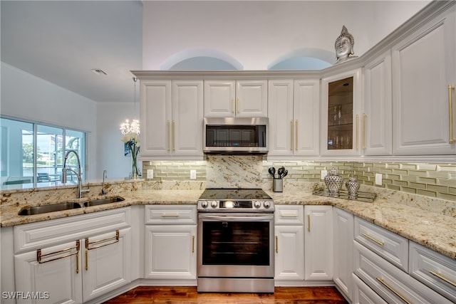 kitchen featuring white cabinetry, sink, tasteful backsplash, appliances with stainless steel finishes, and hardwood / wood-style flooring