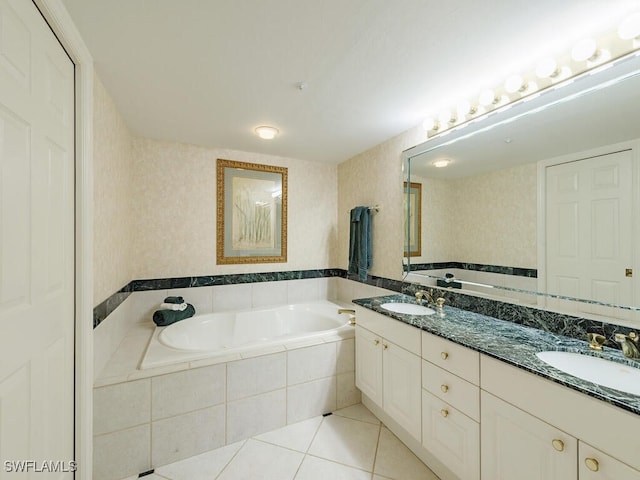 bathroom featuring tile patterned floors, vanity, and a relaxing tiled tub