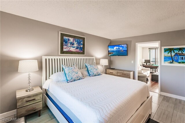 bedroom featuring light wood-type flooring and a textured ceiling