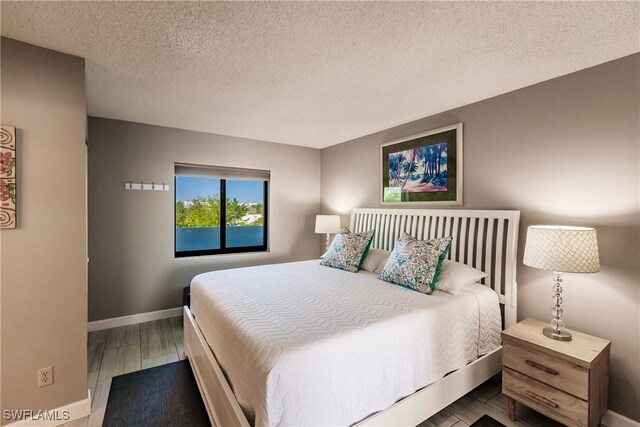 bedroom featuring hardwood / wood-style floors and a textured ceiling