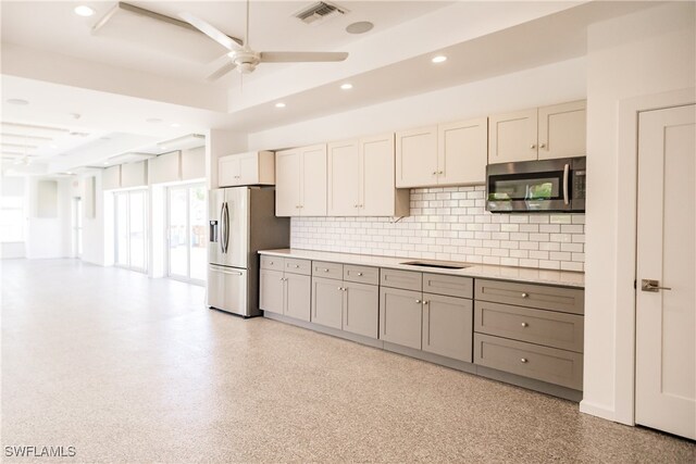 kitchen featuring appliances with stainless steel finishes, tasteful backsplash, and ceiling fan