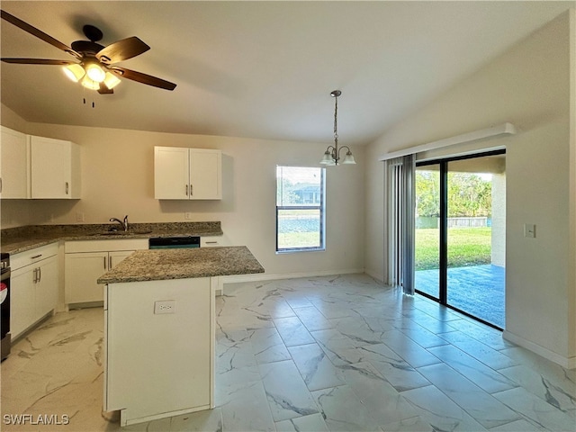 kitchen with a kitchen island, white cabinetry, decorative light fixtures, and vaulted ceiling