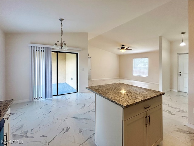 kitchen with ceiling fan with notable chandelier, lofted ceiling, white cabinets, stone countertops, and pendant lighting