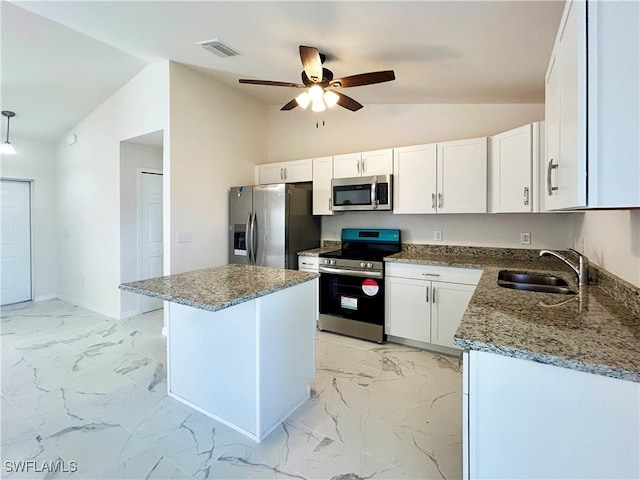 kitchen featuring lofted ceiling, sink, stone countertops, white cabinetry, and appliances with stainless steel finishes