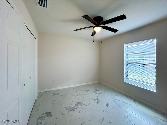 unfurnished bedroom with ceiling fan and a closet