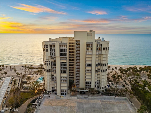 view of building exterior featuring a beach view and a water view