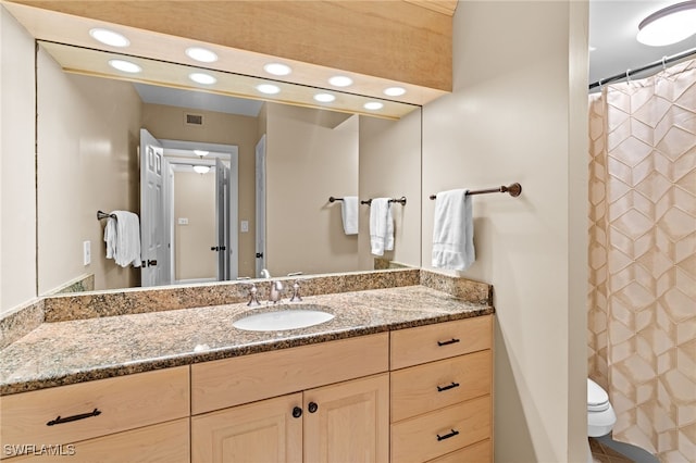 bathroom with toilet, vanity, visible vents, and recessed lighting