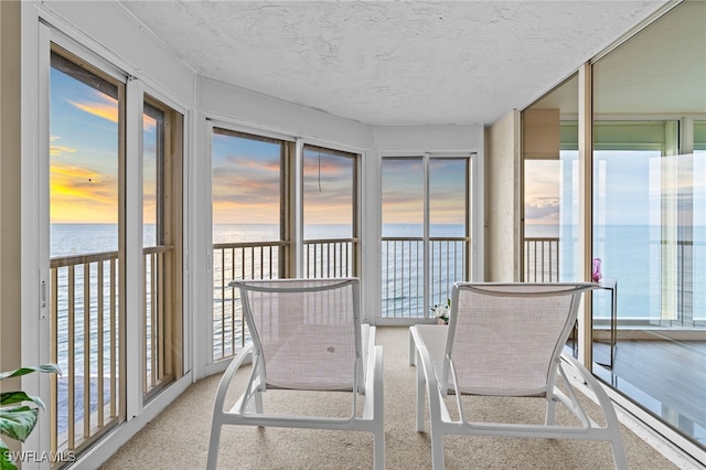 sunroom with a water view and plenty of natural light