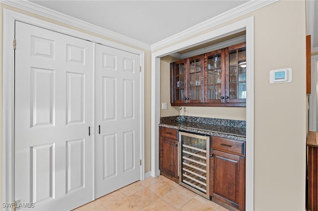 bar with light tile patterned flooring, wine cooler, ornamental molding, and dark stone countertops