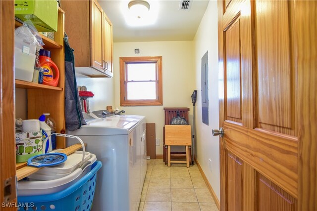 washroom with cabinets, washing machine and dryer, and light tile patterned flooring