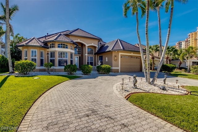 mediterranean / spanish-style home with a front lawn and a garage